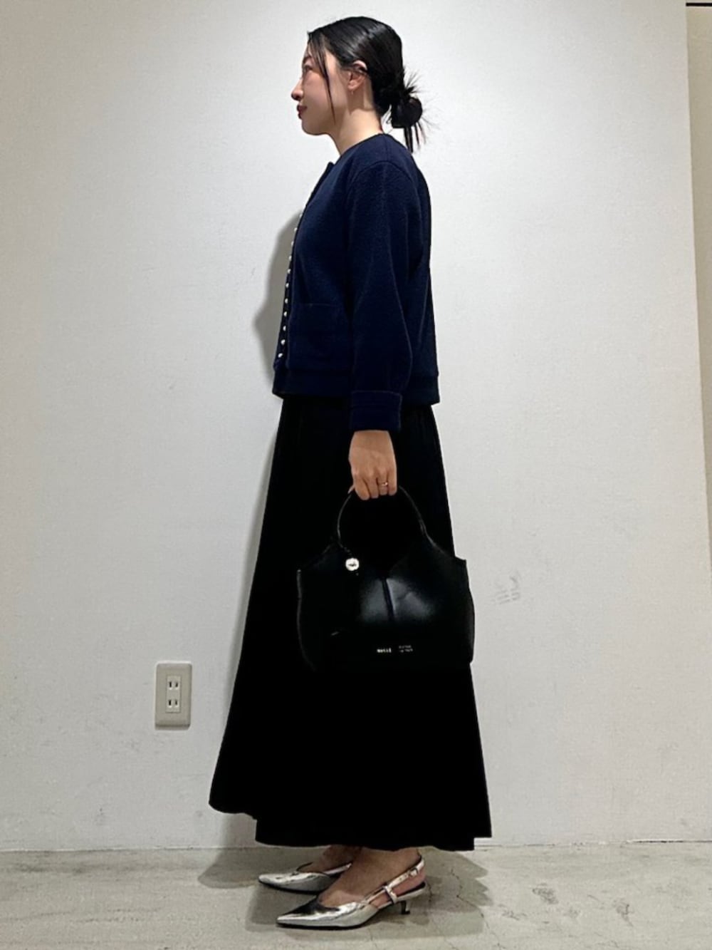 ブラック系のスカート、ブルー系のカーディガン/ボレロ、ブラック系のショルダーバッグを着用したレディースの秋コーディネートの2枚目の写真