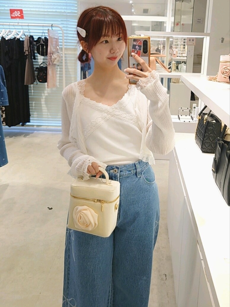 ホワイト系のカーディガン/ボレロ、ブルー系のデニムパンツ、ホワイト系のショルダーバッグを着用したレディースの夏コーディネートの2枚目の写真