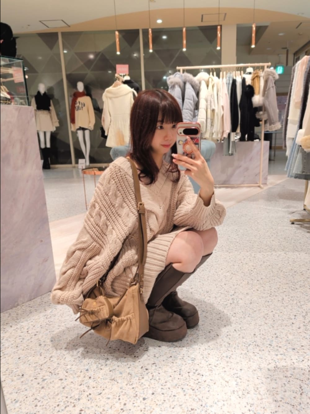 ホワイト系のその他アウター、ピンク系のワンピース、ブラウン系のショルダーバッグを着用したレディースの冬コーディネートの5枚目の写真