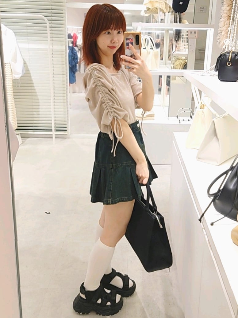 ベージュ系のTシャツ/カットソー、ブルー系のスカート、ブラック系のトートバッグを着用したレディースの夏コーディネートの3枚目の写真