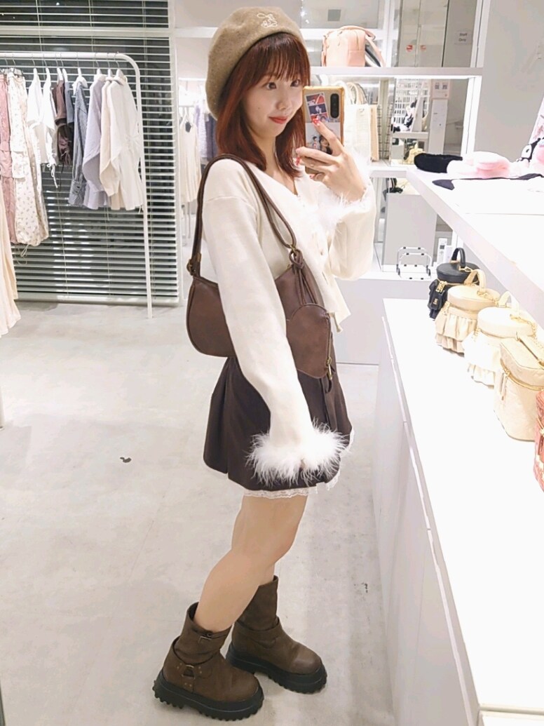 ホワイト系のカーディガン/ボレロ、ホワイト系のキャミソール、ブラウン系のスカートを着用したレディースの秋コーディネートの4枚目の写真