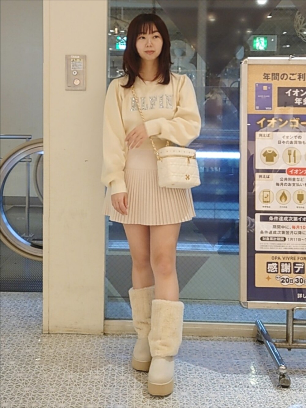 ベージュ系のその他アウター、ホワイト系のニット/セーター、ホワイト系のショルダーバッグを着用したレディースの秋コーディネートの3枚目の写真