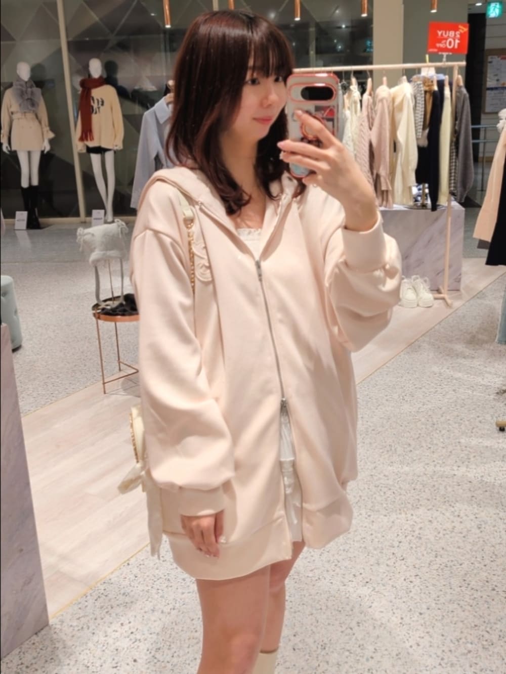 ブルー系のパーカー、ホワイト系のスカート、ホワイト系のブーツを着用したレディースの冬コーディネートの3枚目の写真