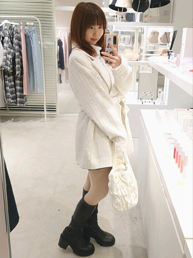 ホワイト系のテーラードジャケット、ホワイト系のハンドバッグを着用したレディースの冬コーディネートの3枚目の写真