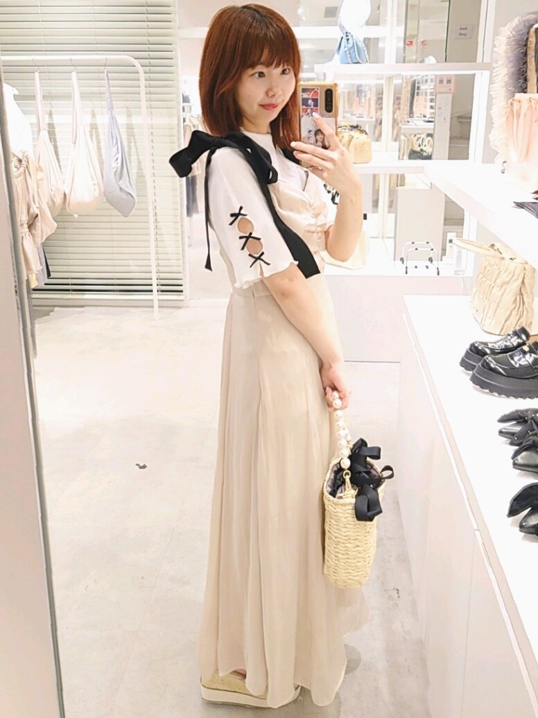 ホワイト系のTシャツ/カットソー、ベージュ系のワンピース、ブラック系のかごバッグを着用したレディースの春コーディネートの3枚目の写真