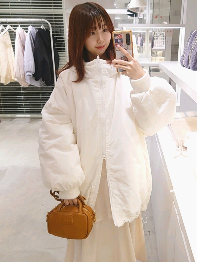 ホワイト系のブルゾン、イエロー系のボストンバッグ、ホワイト系のスカートを着用したレディースの冬コーディネートの2枚目の写真