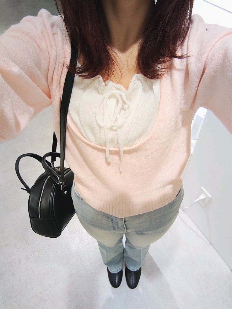 ピンク系のニット/セーター、ブルー系のデニムパンツ、ブラック系のハンドバッグを着用したレディースの冬コーディネートの3枚目の写真