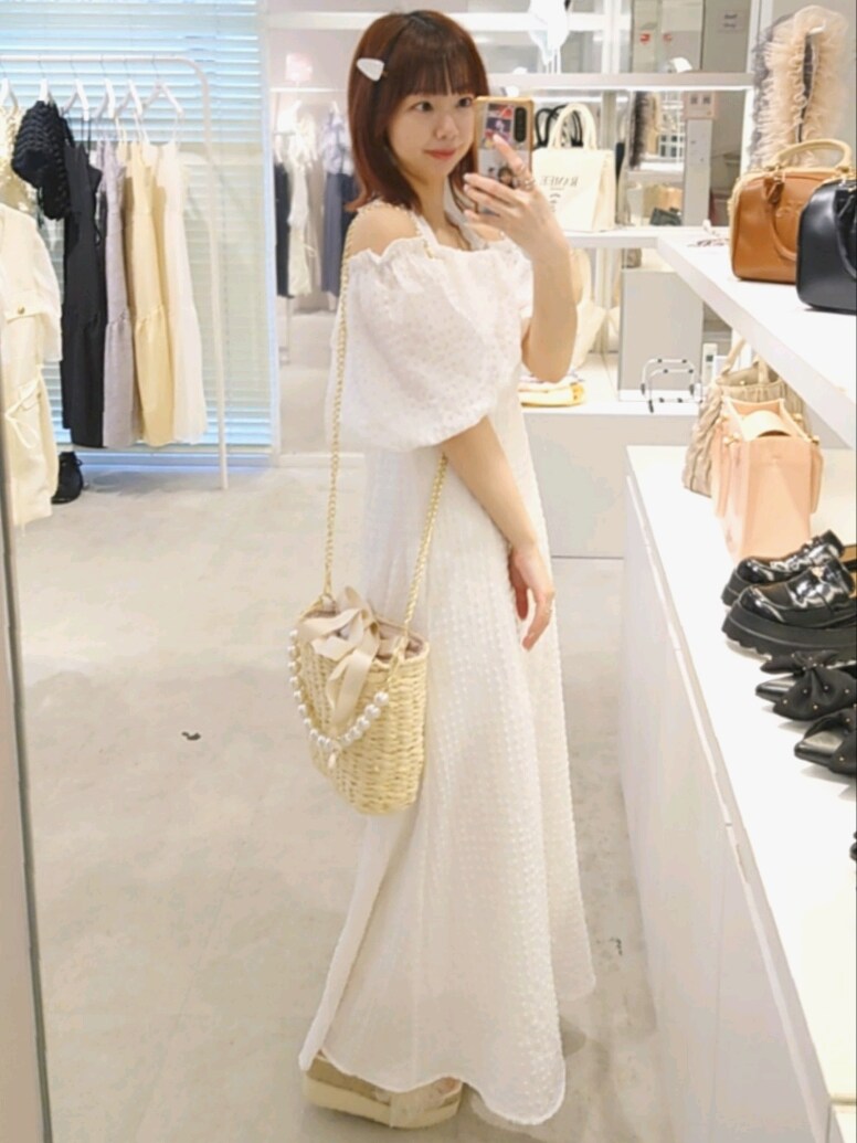 ホワイト系のワンピース、ホワイト系のサンダル、ホワイト系のショルダーバッグを着用したレディースの春コーディネートの3枚目の写真