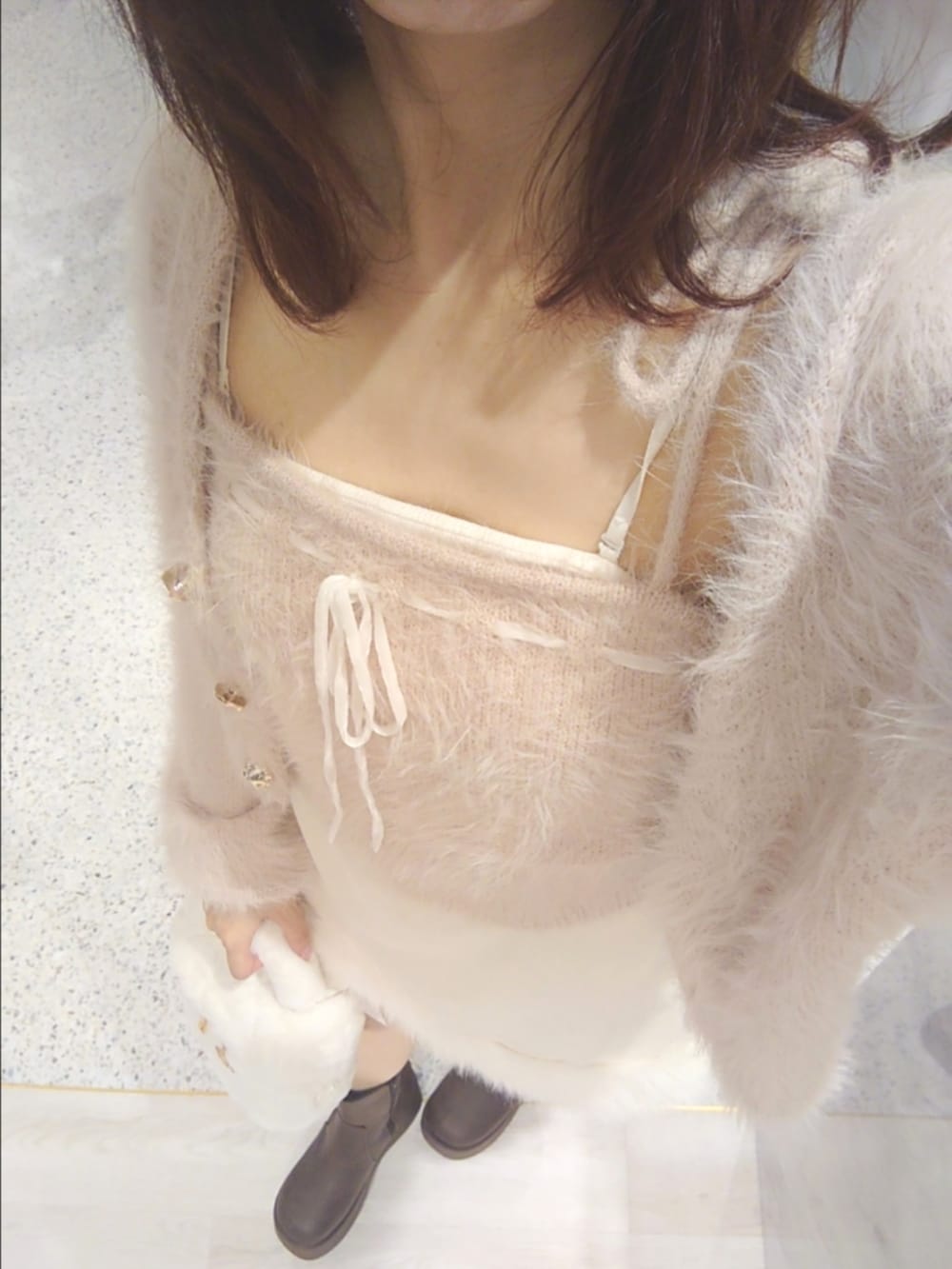 ホワイト系のスカート、ホワイト系のショルダーバッグ、ブラウン系のブーツを着用したレディースの秋コーディネートの2枚目の写真