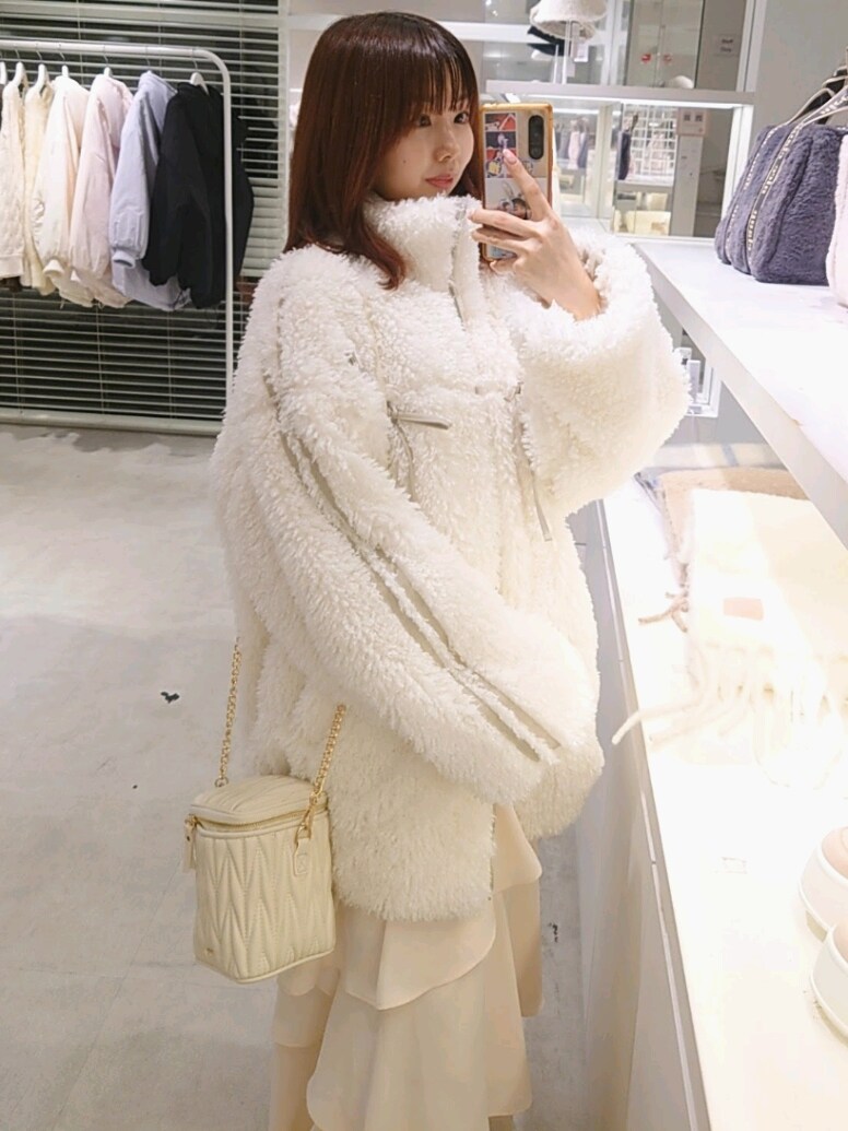 ホワイト系のブルゾン、ホワイト系のスカート、ホワイト系のショルダーバッグを着用したレディースの冬コーディネートの2枚目の写真