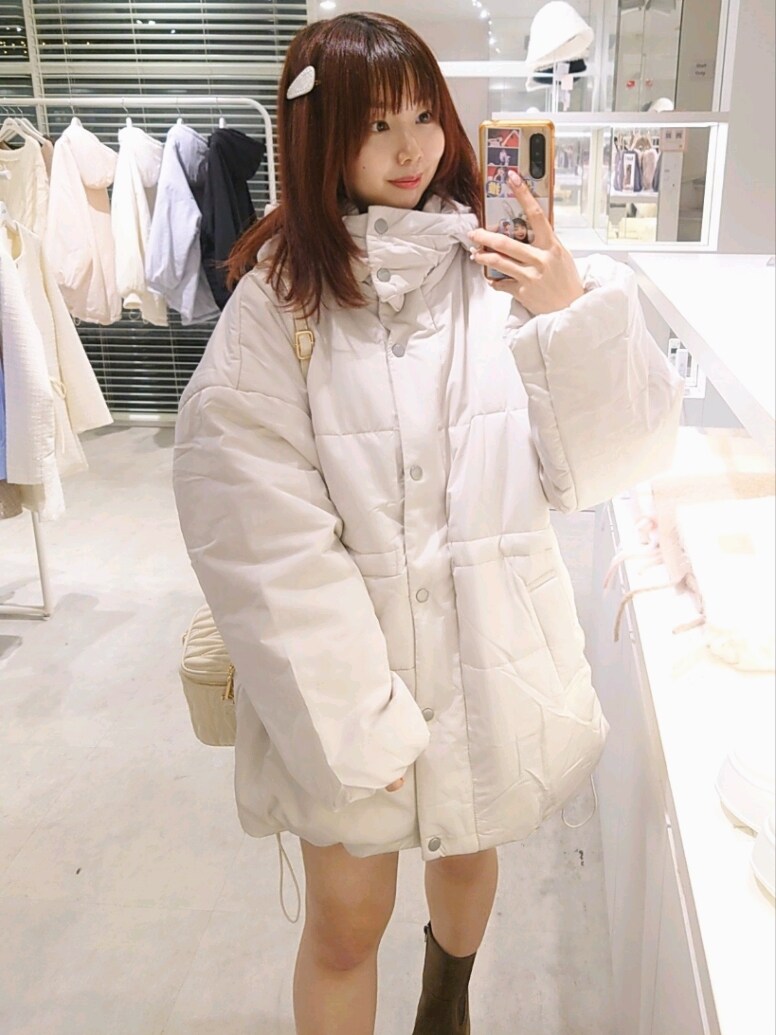 ベージュ系のダウンジャケット/コート、ホワイト系のショルダーバッグ、ブラウン系のブーツを着用したレディースの冬コーディネートの2枚目の写真