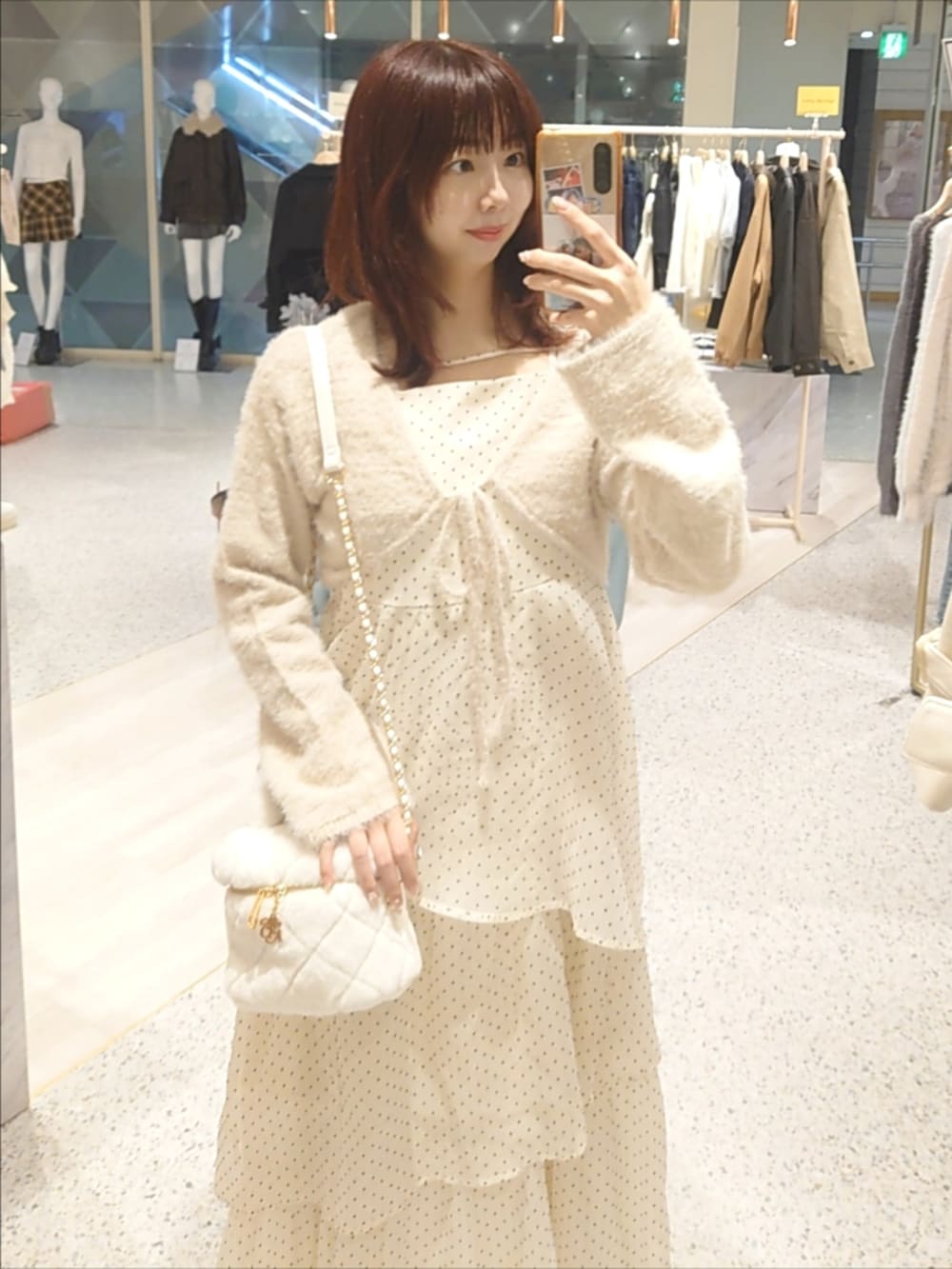 ベージュ系のワンピース、ホワイト系のショルダーバッグ、ホワイト系のパンプスを着用したレディースの秋コーディネートの2枚目の写真