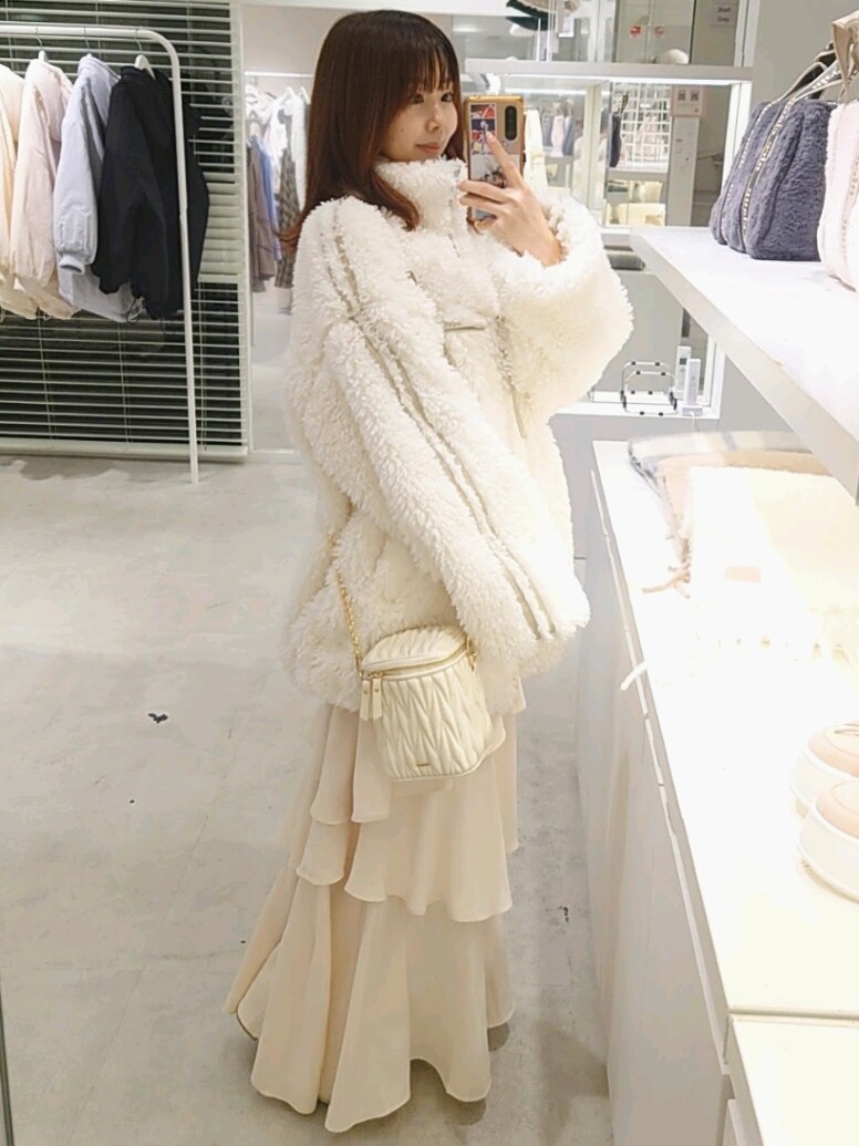 ホワイト系のブルゾン、ホワイト系のスカート、ホワイト系のショルダーバッグを着用したレディースの冬コーディネートの3枚目の写真