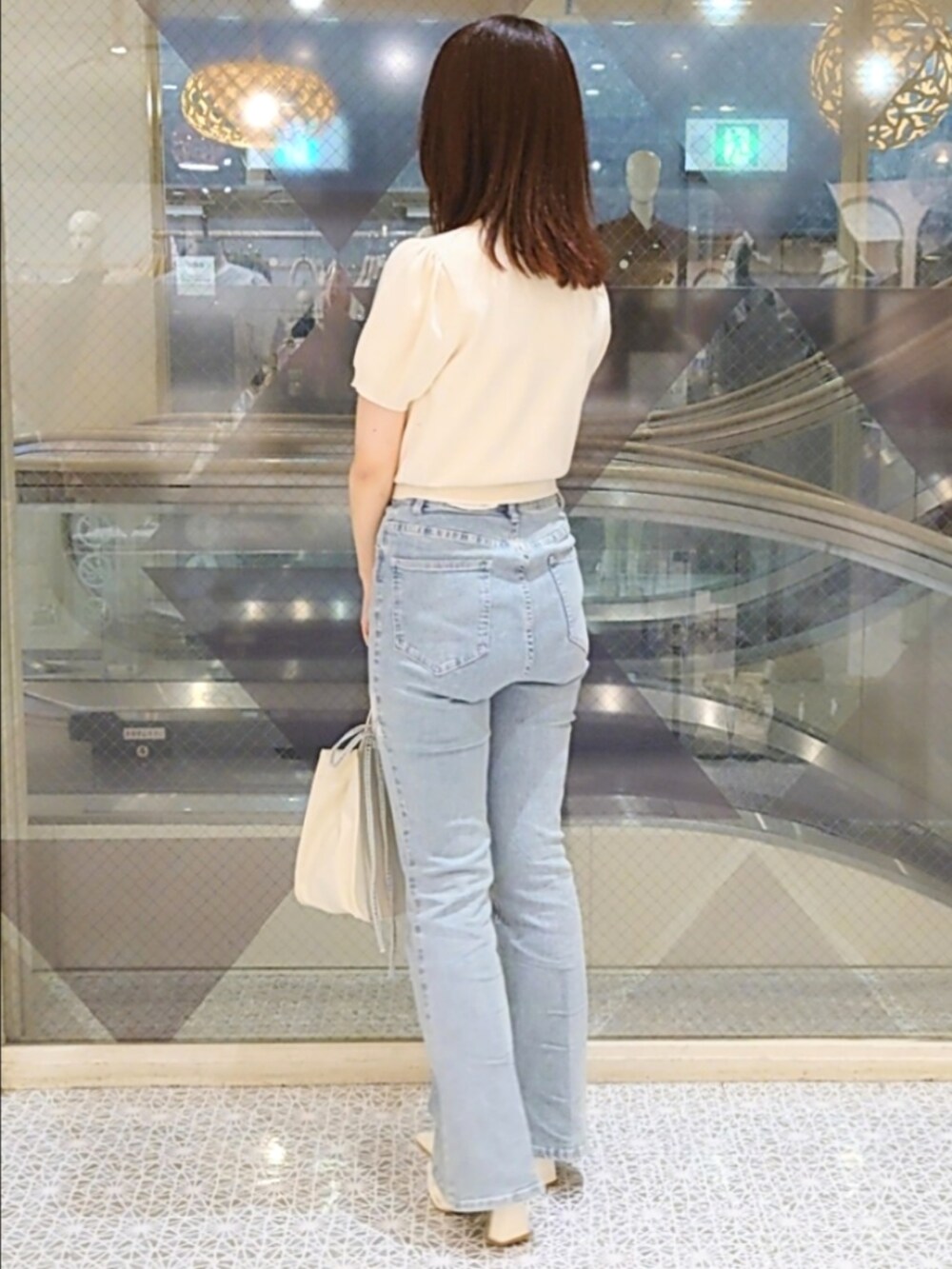 ホワイト系のニット/セーター、ブルー系のデニムパンツ、ホワイト系のパンプスを着用したレディースの秋コーディネートの2枚目の写真