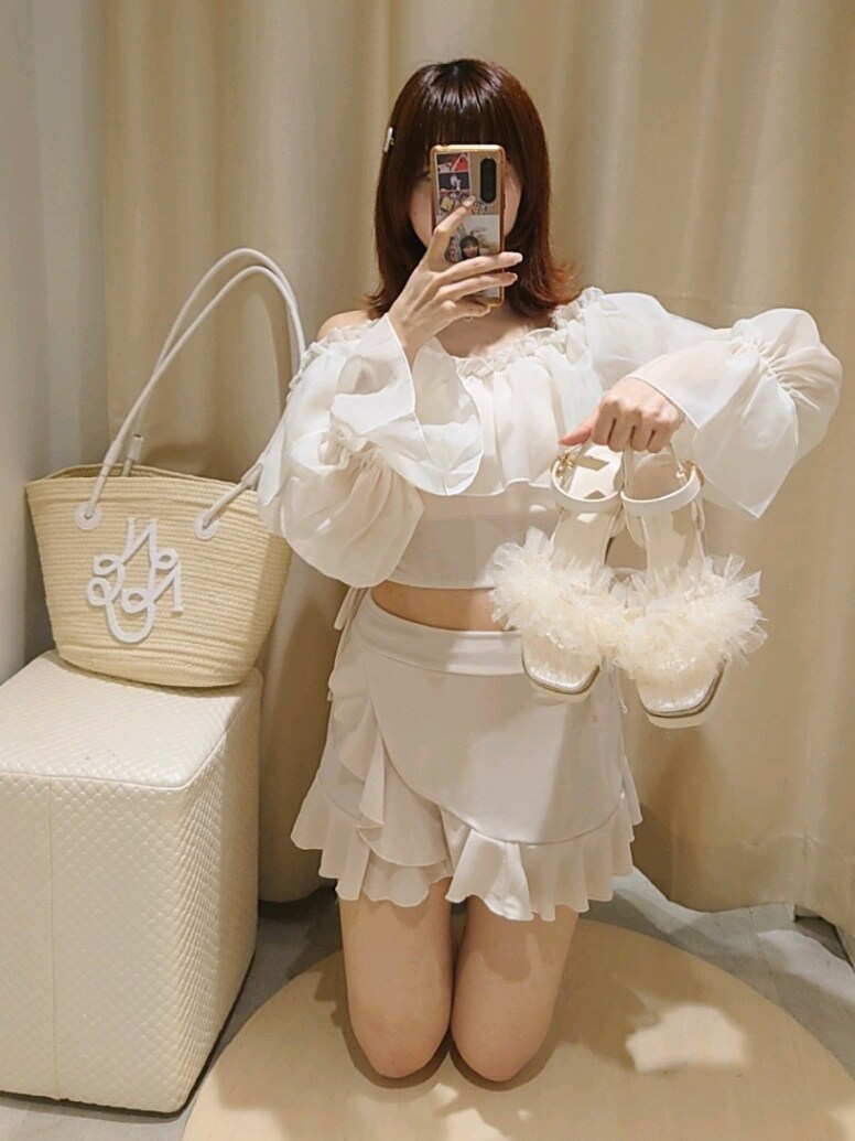 ホワイト系のサンダル、ブルー系のデニムパンツ、ホワイト系のトートバッグを着用したレディースの夏コーディネートの3枚目の写真