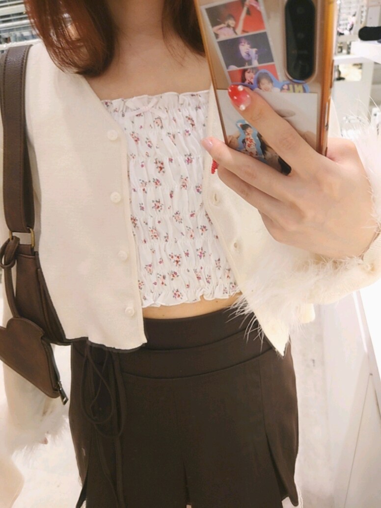 ホワイト系のカーディガン/ボレロ、ホワイト系のキャミソール、ブラウン系のスカートを着用したレディースの秋コーディネートの3枚目の写真