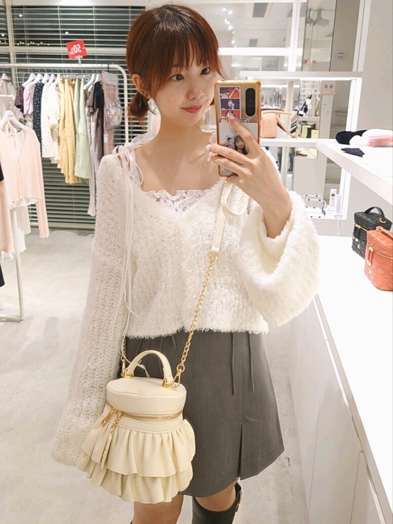 ホワイト系のカーディガン/ボレロ、ホワイト系のキャミソール、グレー系のスカートを着用したレディースの秋コーディネートの2枚目の写真