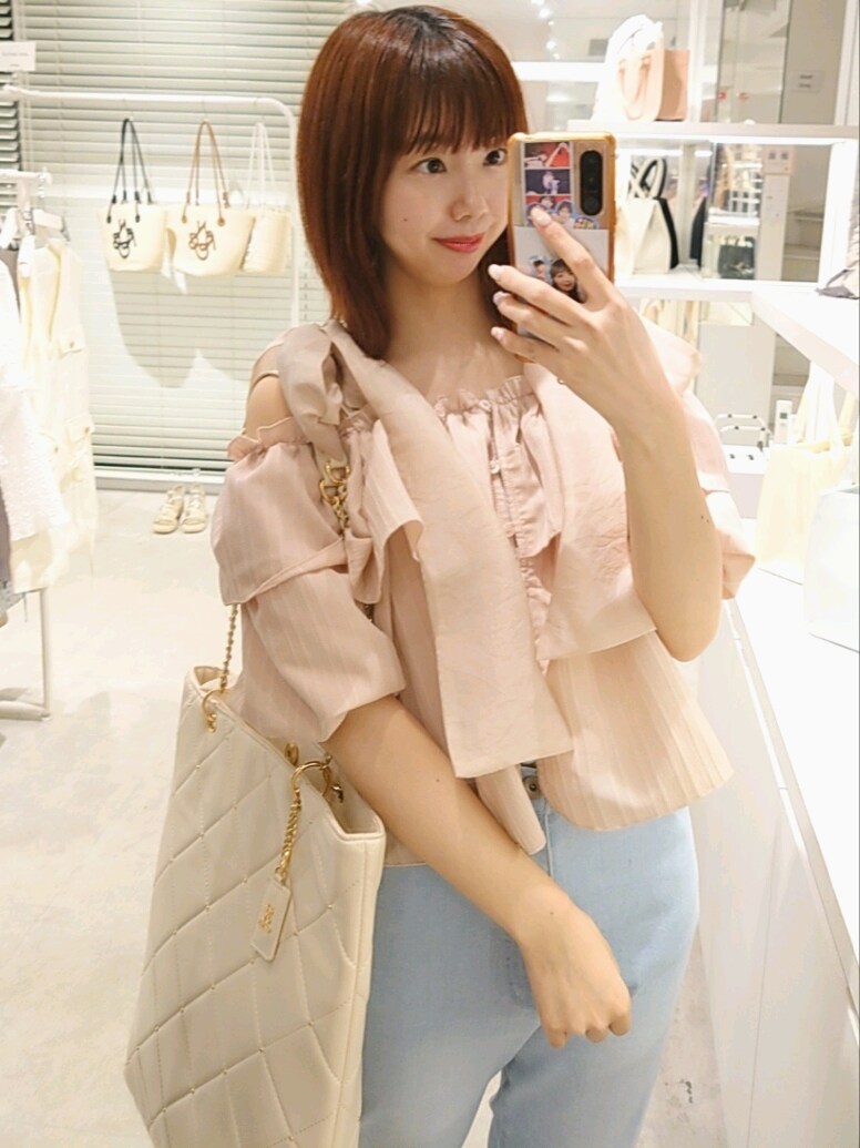 ピンク系のシャツ/ブラウス、ホワイト系のトートバッグ、ブルー系のデニムパンツを着用したレディースの夏コーディネートの2枚目の写真