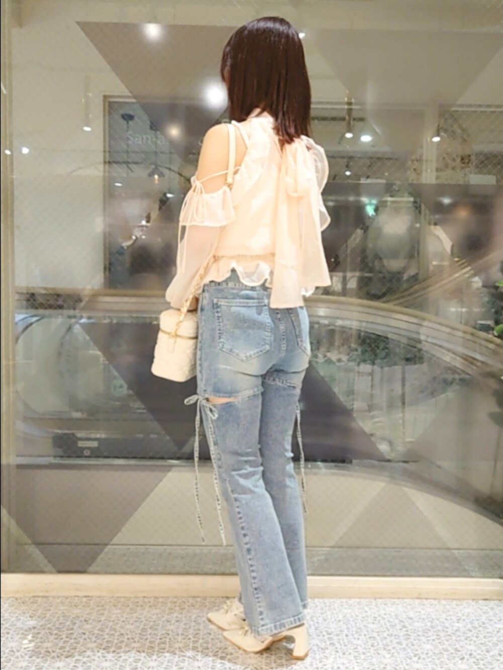ピンク系のシャツ/ブラウス、ホワイト系のショルダーバッグ、ブルー系のデニムパンツを着用したレディースの秋コーディネートの3枚目の写真