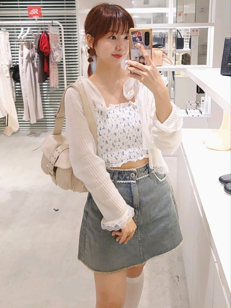 ホワイト系のカーディガン/ボレロ、ホワイト系のショルダーバッグ、ホワイト系のスニーカーを着用したレディースの秋コーディネートの2枚目の写真