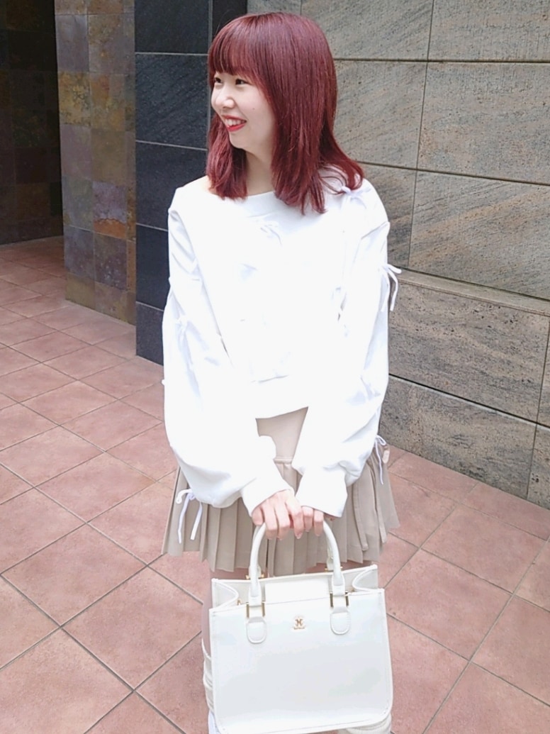 ホワイト系のスウェット、ベージュ系のスカート、ホワイト系のスニーカーを着用したレディースの春コーディネートの2枚目の写真