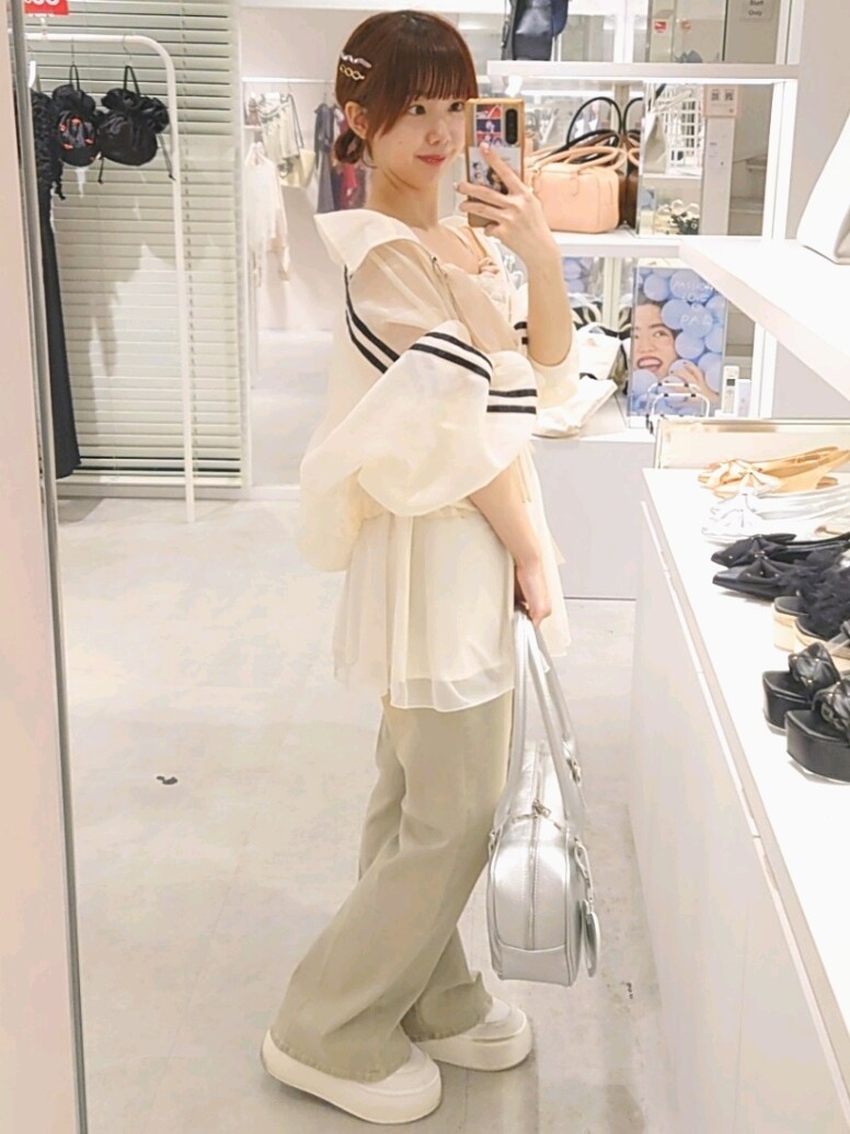 ホワイト系のキャミソール、ホワイト系のブルゾン、シルバー系のボストンバッグを着用したレディースの夏コーディネートの3枚目の写真