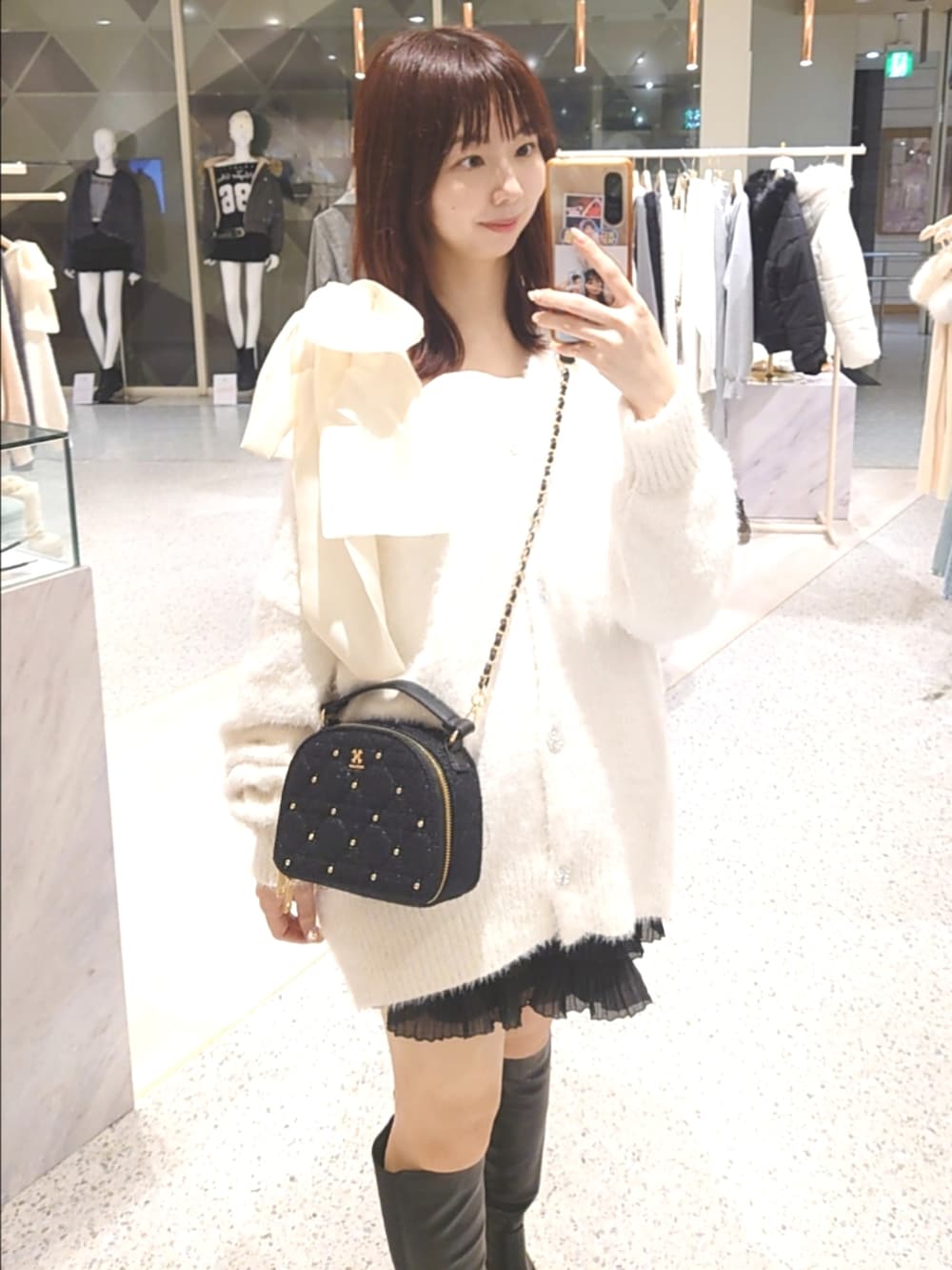 ホワイト系のカーディガン/ボレロ、ピンク系のキャミソール、ブラック系のスカートを着用したレディースの秋コーディネートの2枚目の写真