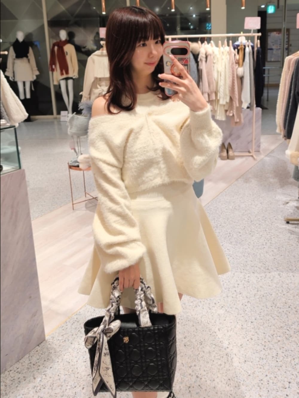 ホワイト系のワンピース、ブラック系のトートバッグ、ブラック系のパンプスを着用したレディースの冬コーディネートの2枚目の写真