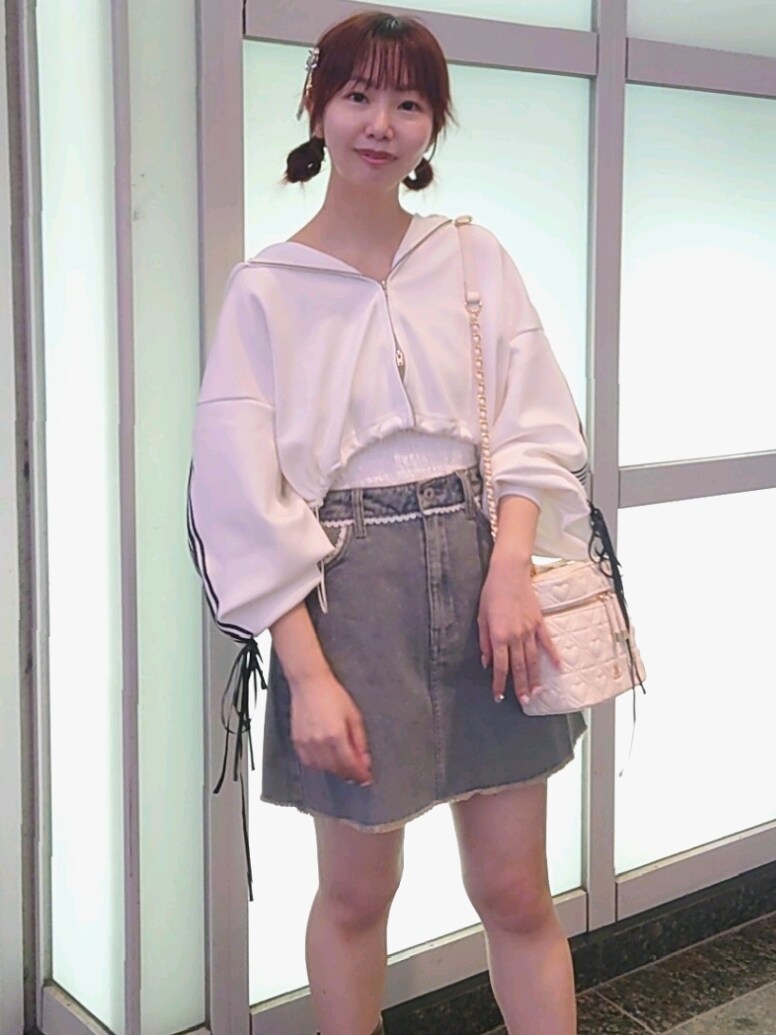 ホワイト系のパーカー、ホワイト系のキャミソール、ブルー系のスカートを着用したレディースの秋コーディネートの3枚目の写真