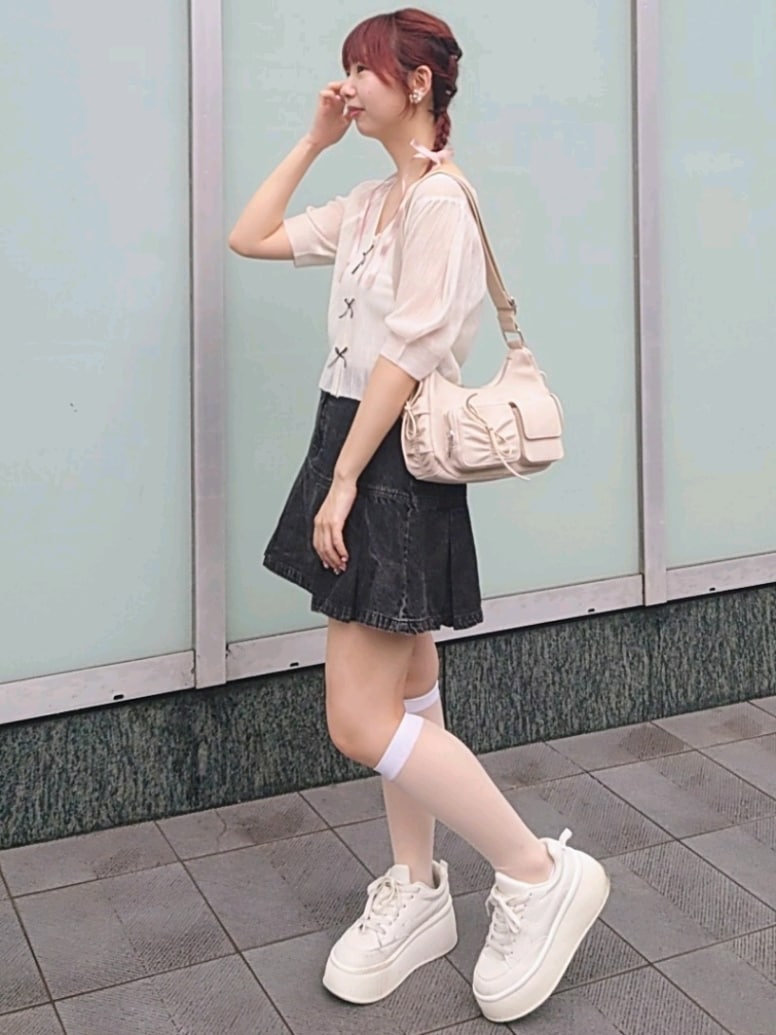 ホワイト系のショルダーバッグ、ホワイト系のスニーカー、ホワイト系のキャミソールを着用したレディースの夏コーディネートの3枚目の写真