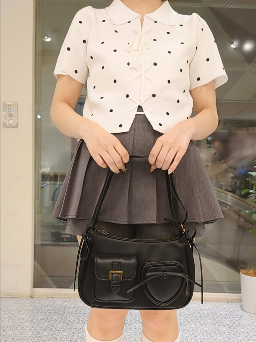 ホワイト系のニット/セーター、グレー系のその他パンツ、ブラック系のショルダーバッグを着用したレディースの夏コーディネートの3枚目の写真