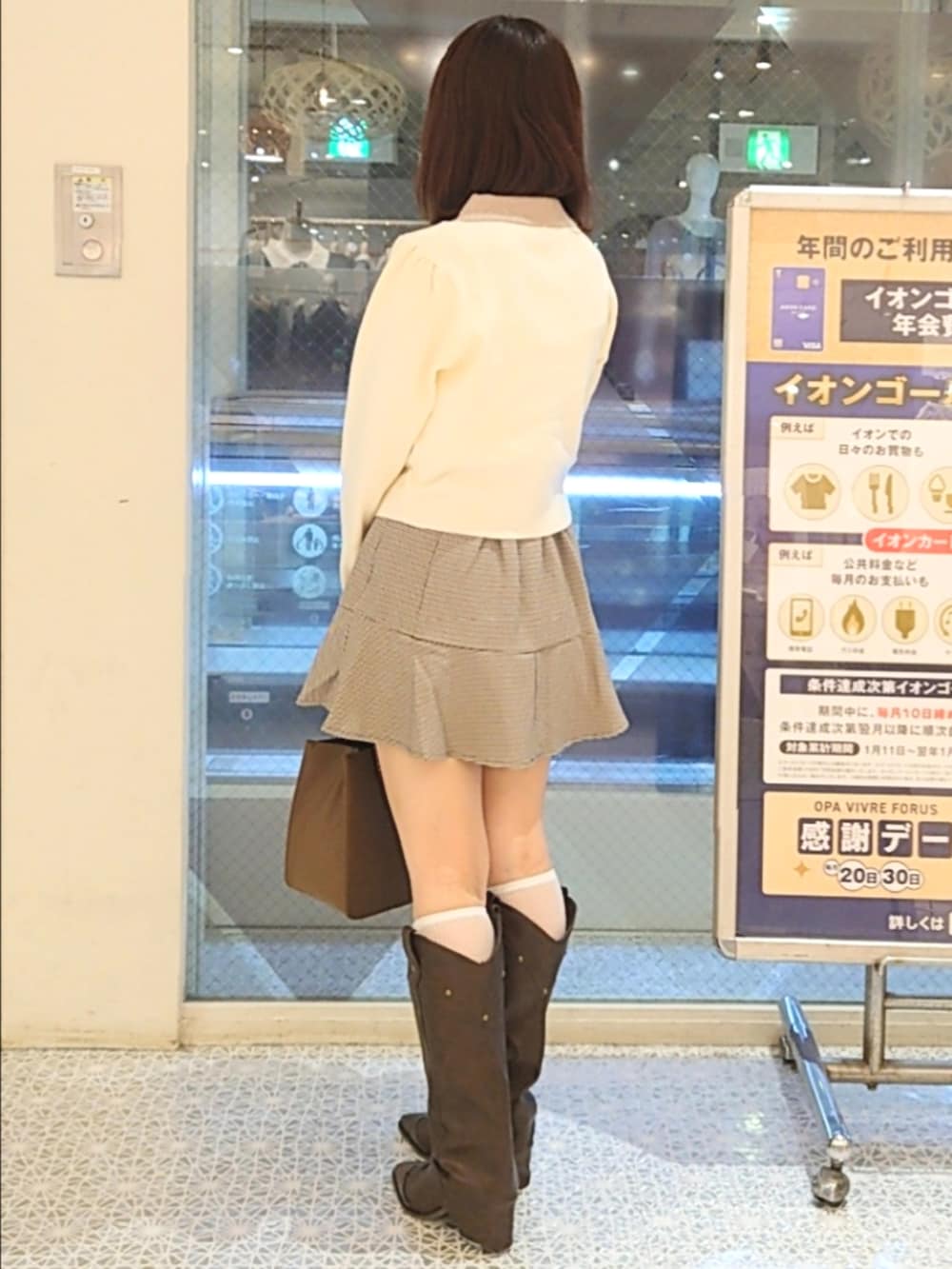 ホワイト系のニット/セーター、ブラウン系のスカート、ブラウン系のブーツを着用したレディースの秋コーディネートの3枚目の写真