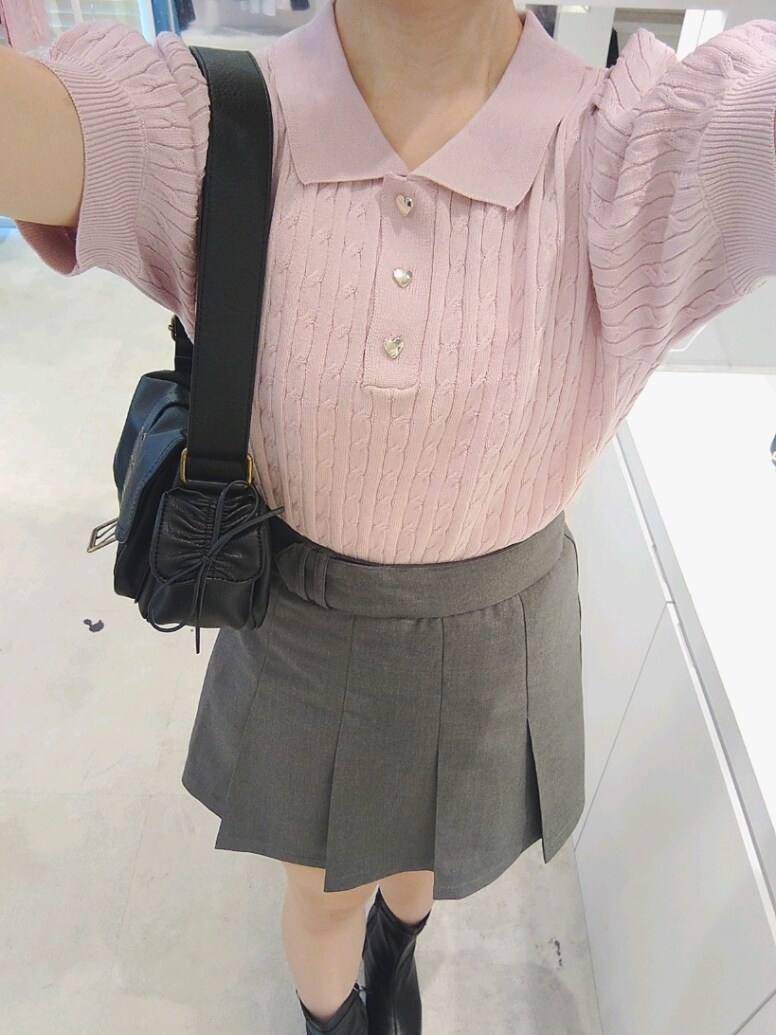 ピンク系のニット/セーター、グレー系のスカート、ブラック系のショルダーバッグを着用したレディースの夏コーディネートの3枚目の写真