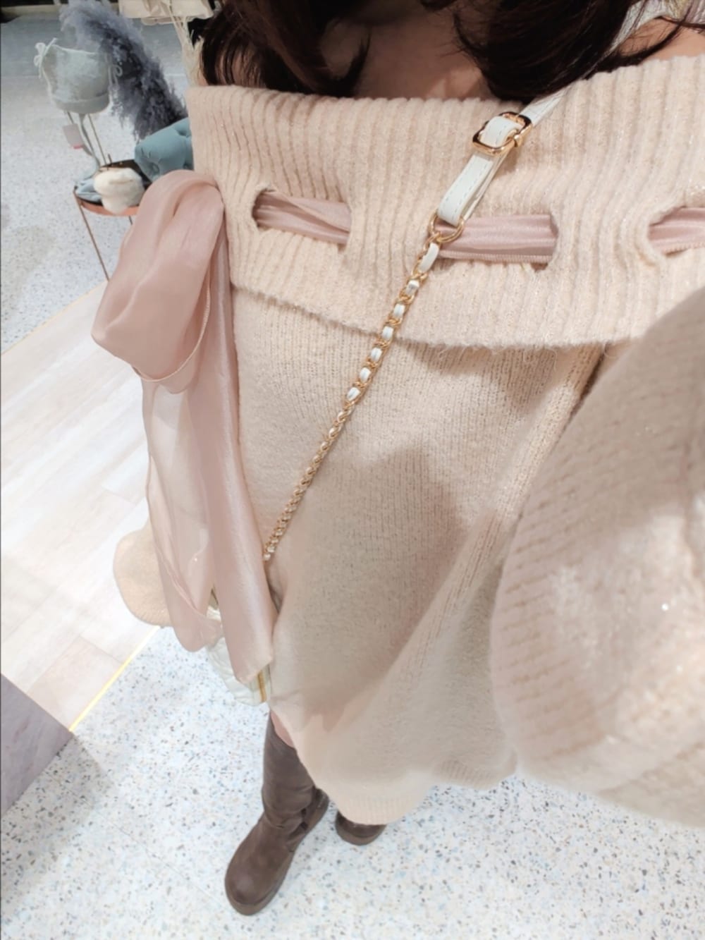 ピンク系のワンピース、ホワイト系のショルダーバッグ、ブラウン系のブーツを着用したレディースの冬コーディネートの2枚目の写真