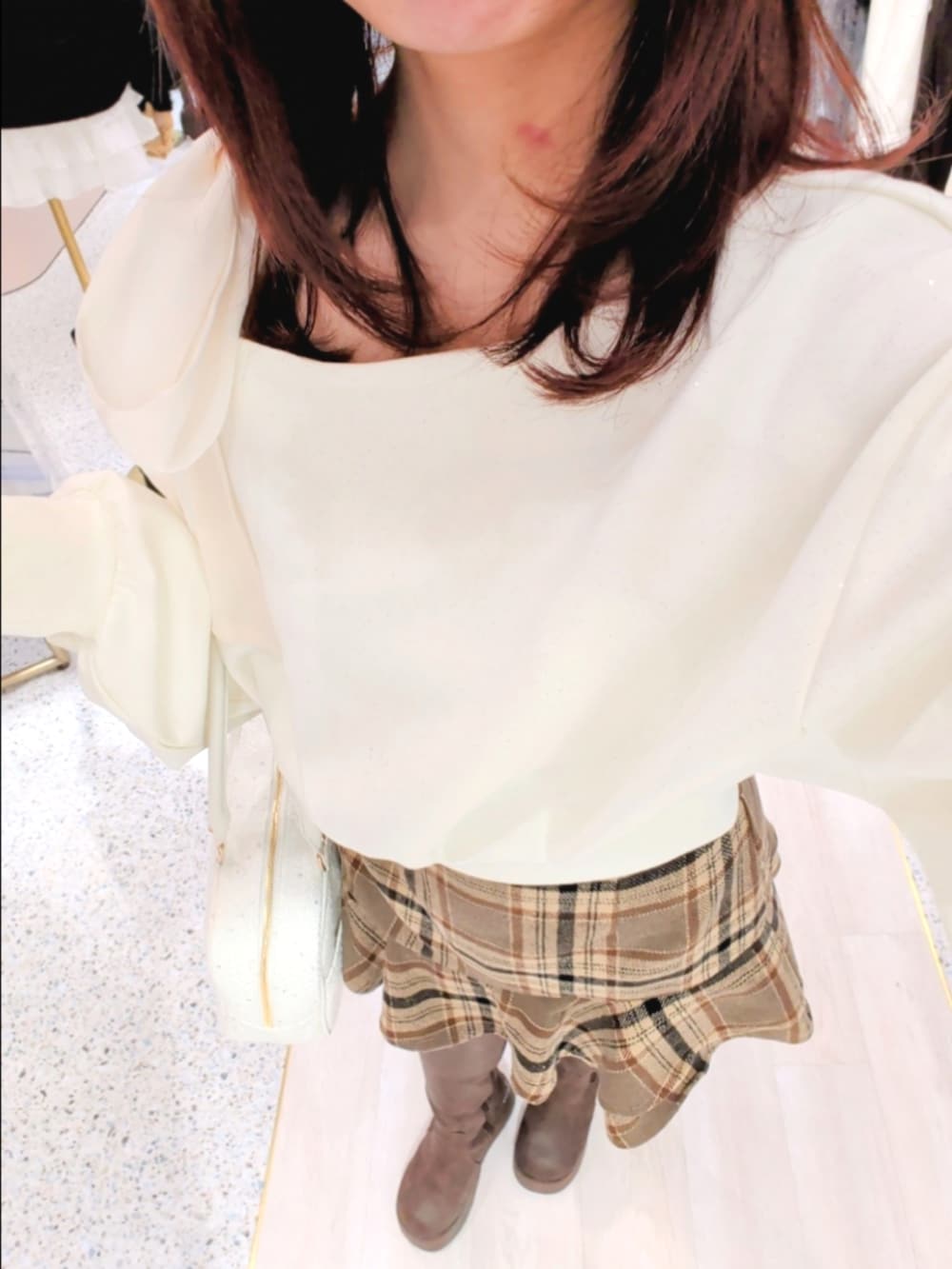 ホワイト系のブルゾン、ホワイト系のTシャツ/カットソー、ブラウン系のスカートを着用したレディースの冬コーディネートの3枚目の写真