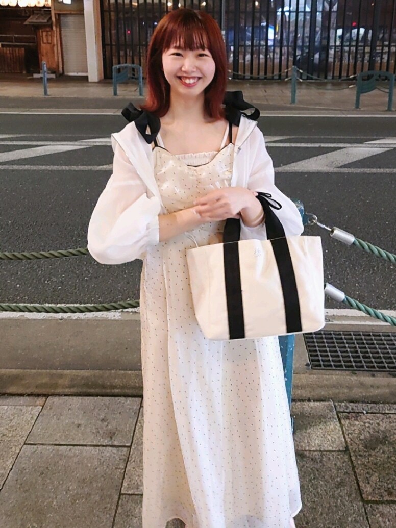 ホワイト系のマウンテンパーカー、ベージュ系のワンピース、ホワイト系のサンダルを着用したレディースの春コーディネートの2枚目の写真