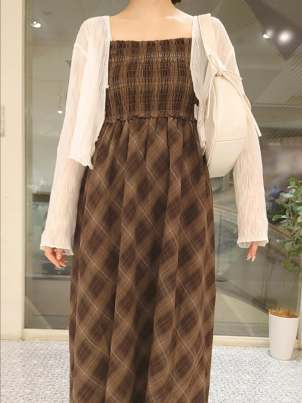 ホワイト系のカーディガン/ボレロ、ブラウン系のワンピース、ホワイト系のショルダーバッグを着用したレディースの夏コーディネートの4枚目の写真