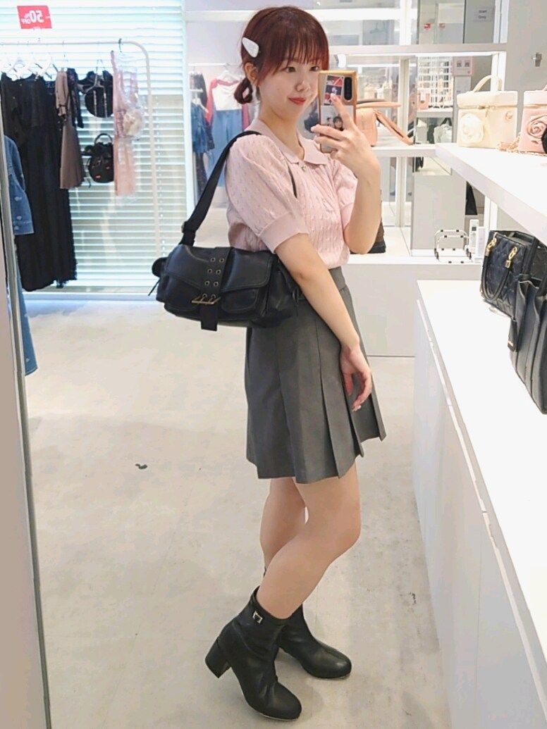 ピンク系のニット/セーター、グレー系のスカート、ブラック系のショルダーバッグを着用したレディースの夏コーディネートの4枚目の写真