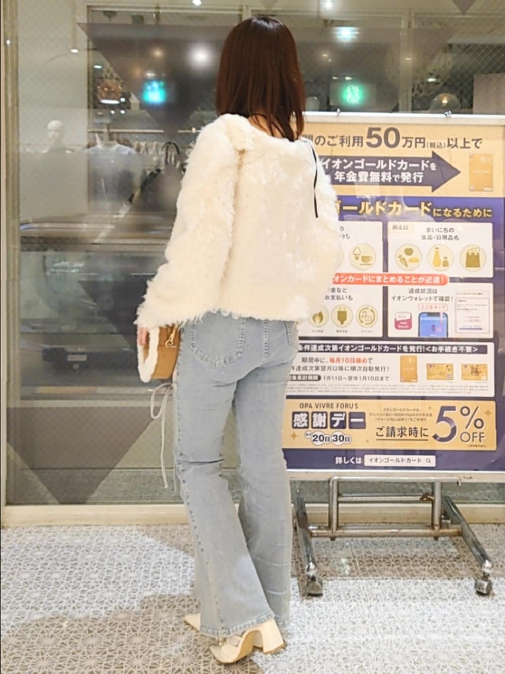ホワイト系のカーディガン/ボレロ、その他のキャミソール、ブルー系のデニムパンツを着用したレディースの秋コーディネートの2枚目の写真