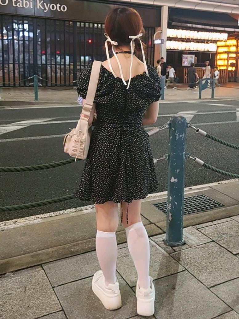 ブラック系のワンピース、ホワイト系のショルダーバッグ、ホワイト系のスニーカーを着用したレディースの夏コーディネートの4枚目の写真