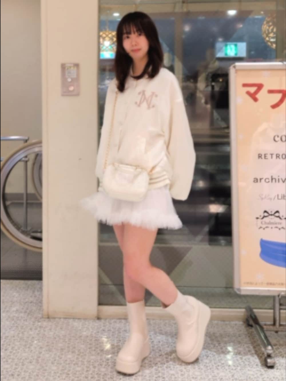 ホワイト系のスカジャン、ホワイト系のスカート、ホワイト系のショルダーバッグを着用したレディースの冬コーディネートの4枚目の写真