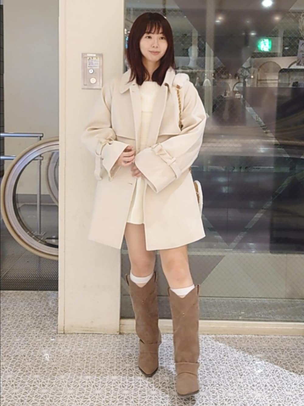 ホワイト系のチェスターコート、ホワイト系のワンピース、ベージュ系のショルダーバッグを着用したレディースの秋コーディネートの3枚目の写真