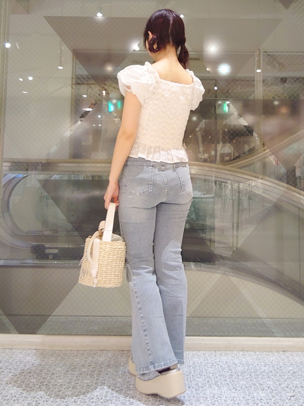 ホワイト系のシャツ/ブラウス、ブルー系のデニムパンツ、ホワイト系のかごバッグを着用したレディースの夏コーディネートの3枚目の写真