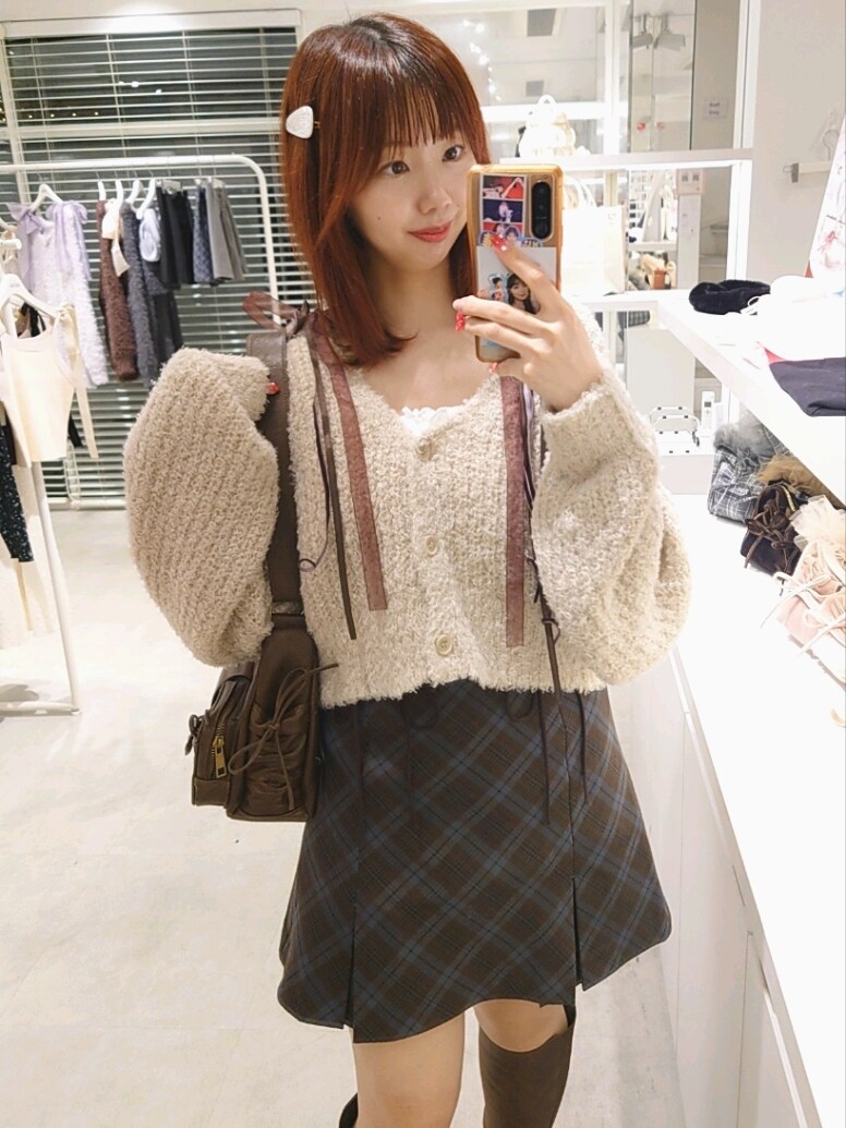 ベージュ系のカーディガン/ボレロ、ブラウン系のショルダーバッグ、ブラウン系のスカートを着用したレディースの秋コーディネートの2枚目の写真