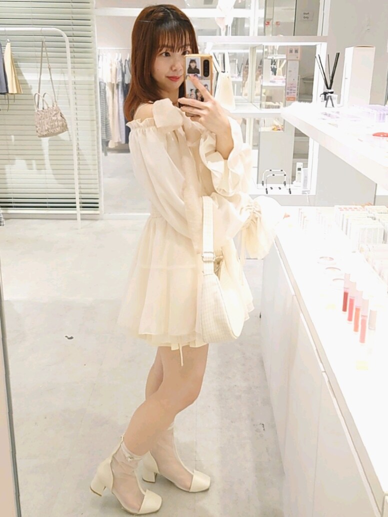 ホワイト系のシャツ/ブラウス、ホワイト系のブーツ、ベージュ系のショルダーバッグを着用したレディースの春コーディネートの3枚目の写真