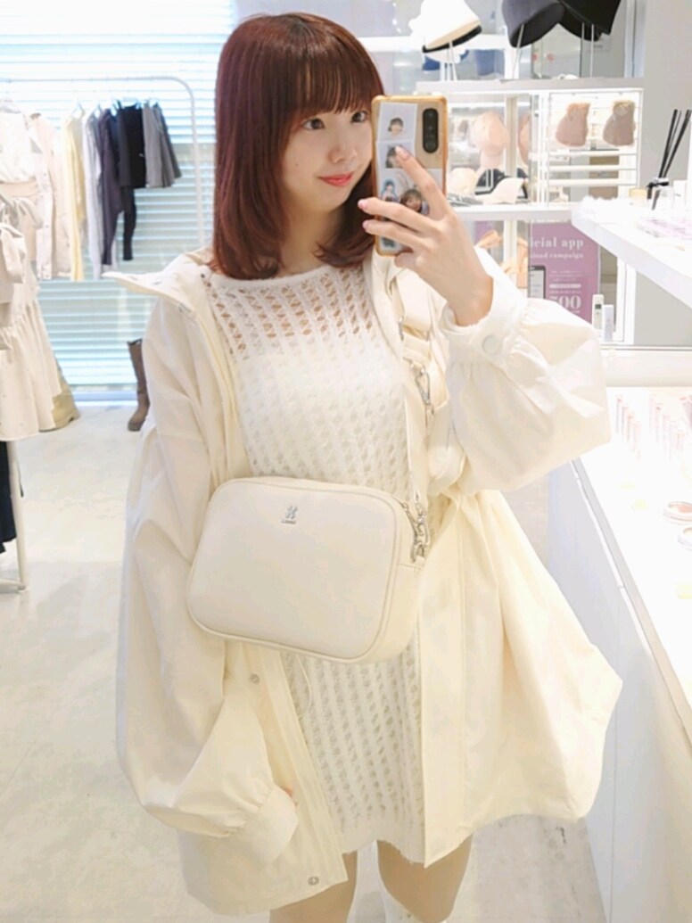 ホワイト系のマウンテンパーカー、ホワイト系のボディバッグ/ウエストポーチ、ホワイト系のスニーカーを着用したレディースの春コーディネートの2枚目の写真