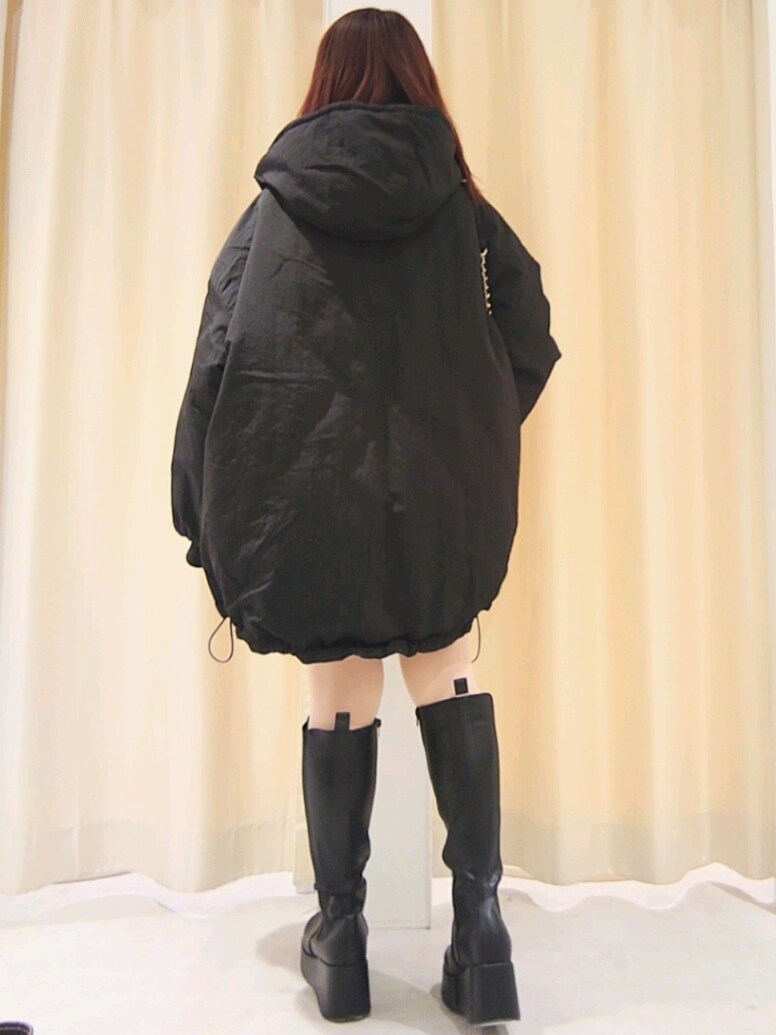 ブラック系のブルゾン、ホワイト系のカーディガン/ボレロ、ブラック系のショルダーバッグを着用したレディースの冬コーディネートの6枚目の写真