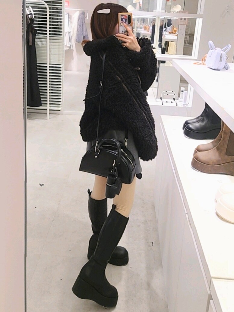 ブラック系のブルゾン、グレー系のスウェット、ブラック系のハンドバッグを着用したレディースの冬コーディネートの4枚目の写真