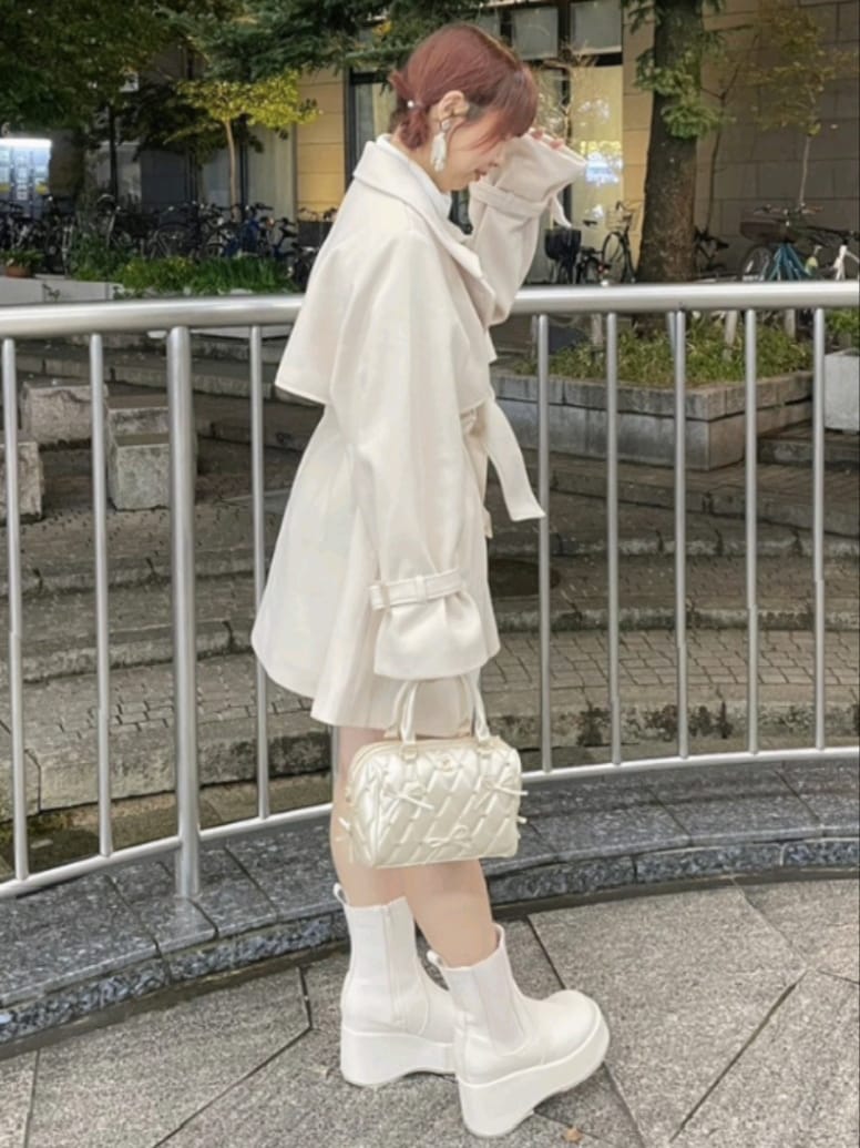 ホワイト系のチェスターコート、ブラウン系のチェスターコート、ホワイト系のTシャツ/カットソーを着用したレディースの秋コーディネートの4枚目の写真