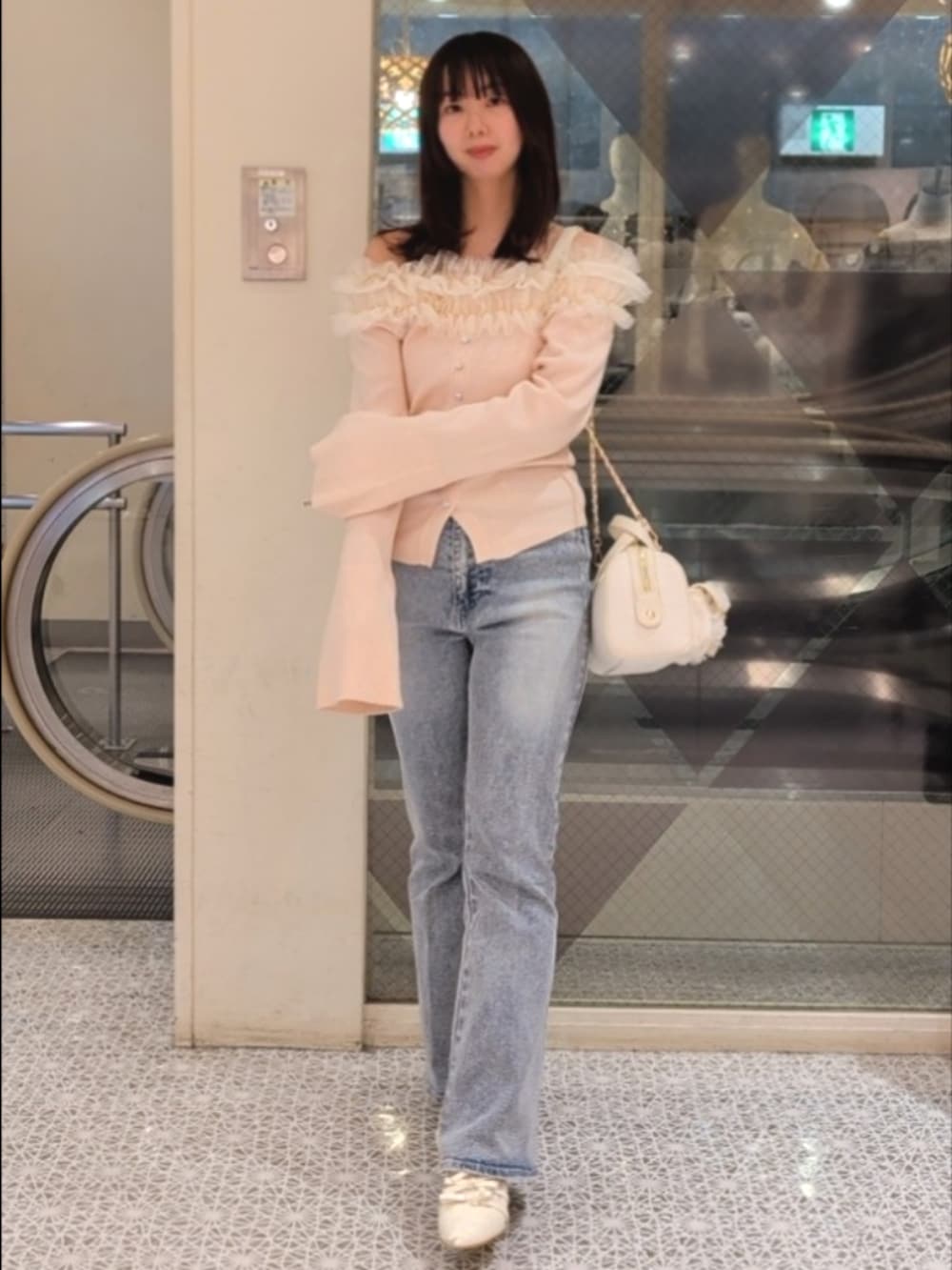 ピンク系のニット/セーター、ブルー系のデニムパンツ、ホワイト系のボストンバッグを着用したレディースの冬コーディネートの3枚目の写真